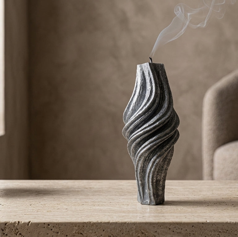 Decorative vase with wavy design on a table with a blurred background