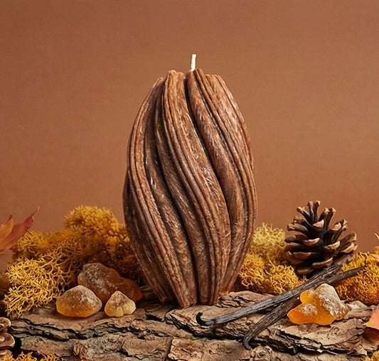 Decorative candle on a rustic log with autumn elements like leaves and pinecones.