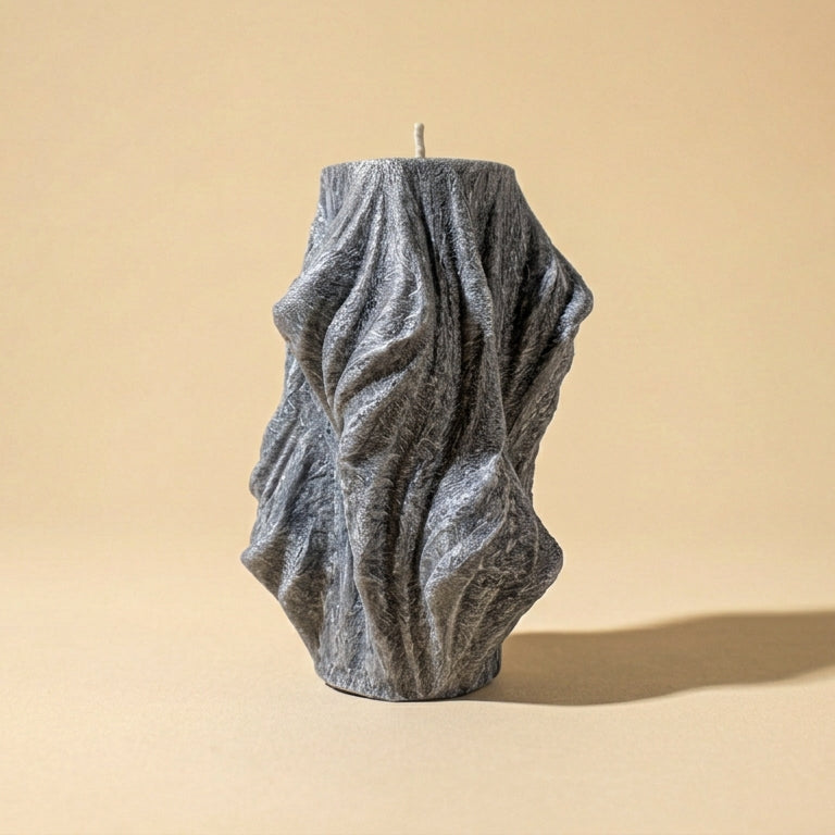 Textured gray candle on a beige background