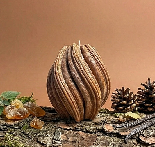 Decorative candle on a log with natural elements on a brown background